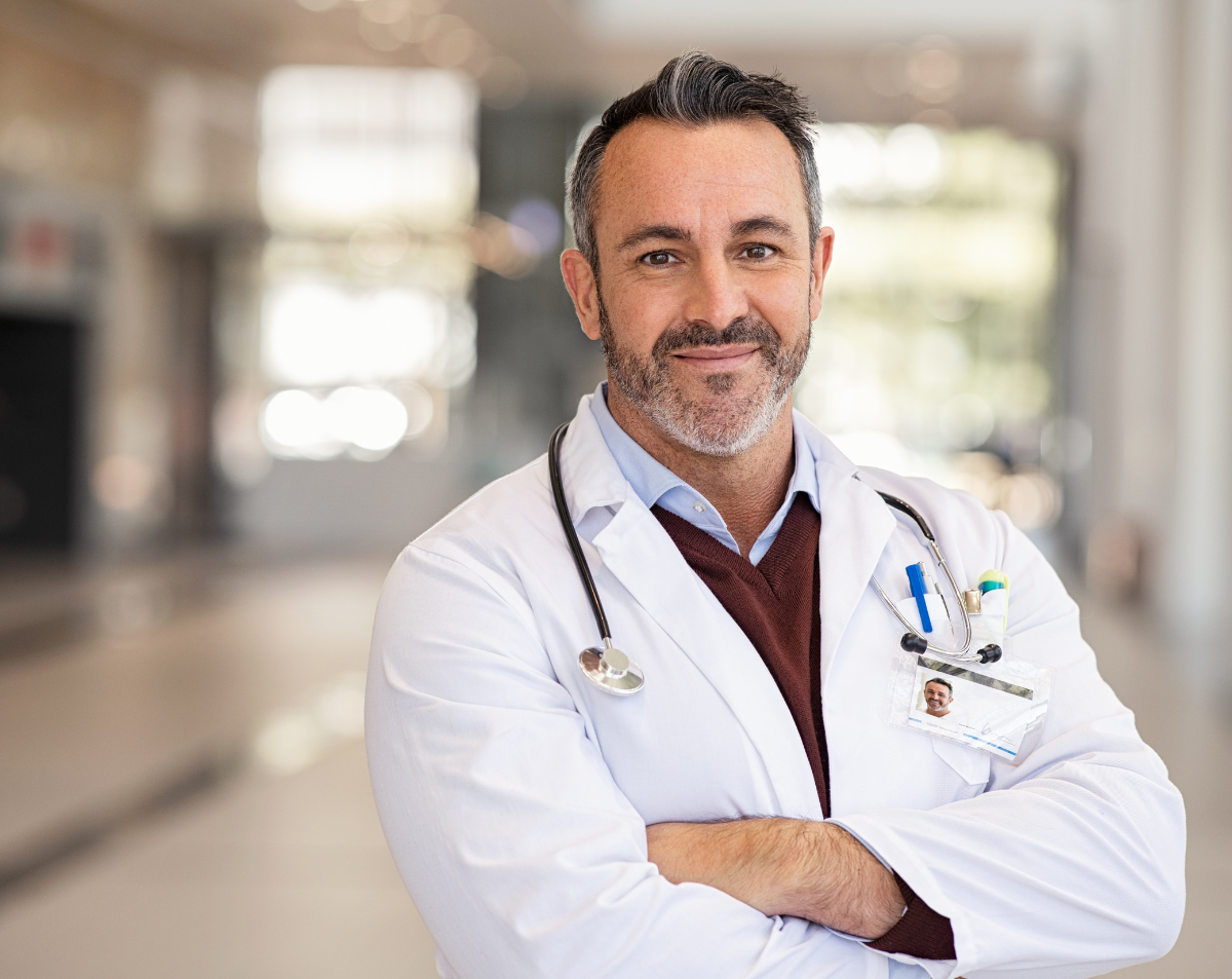 Concierge physician in white coat smiling confidently, emphasizing personalized healthcare availability, including weekends, at Desert Mobile Medical in Scottsdale.