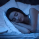 Woman sleeping peacefully illustrating improved sleep quality and energized mornings.