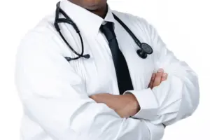Male doctor in a white shirt and tie, smiling with arms crossed.