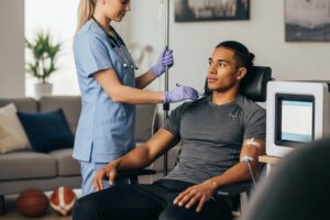Athlete receiving mobile IV therapy in a comfortable home setting, highlighting performance and recovery